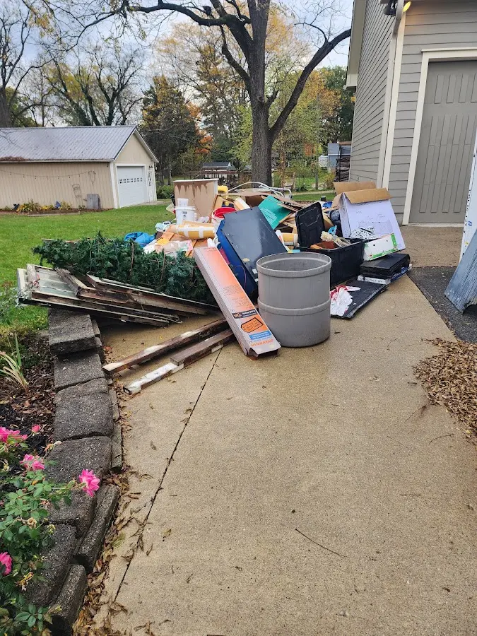 Dumpster being loaded with debris for 12 Yard Dumpster Rental in St. Peter